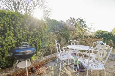 a bbq and chairs and a table and a grill at Rosedale in St Ives