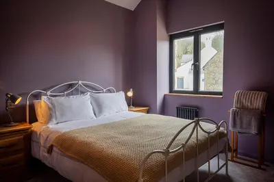 a bedroom with a bed and a window at Middle Barn at Cusgarne Manor, adults only in Cusgarne