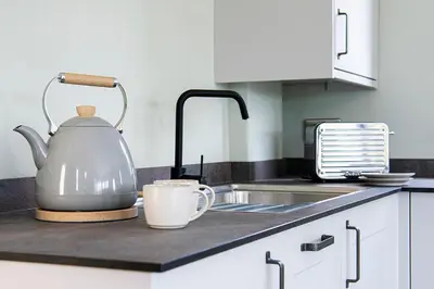 a tea kettle and a cup on a kitchen counter at Middle Barn at Cusgarne Manor, adults only in Cusgarne
