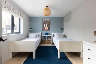 two beds in a bedroom with blue walls at Tamarisk in Portreath