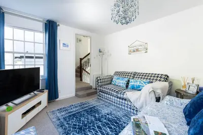 a living room with a couch and a tv at The Old Courthouse in Saint Mawes