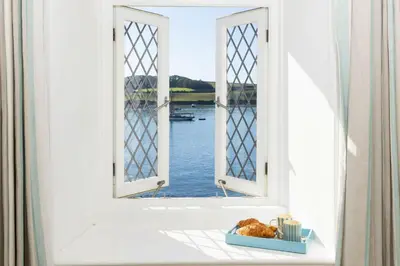 an open window with a view of the water at The Old Courthouse in Saint Mawes