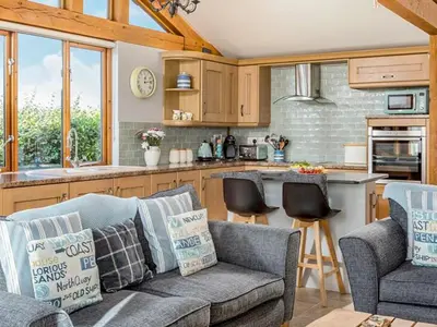 a living room with a couch and a kitchen at The Old Smithy in Bude