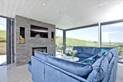 a living room with blue couches and a fireplace at Watergate Horizon in Porth