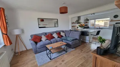 a living room with a blue couch and a table at Heatherbell in Carbis Bay
