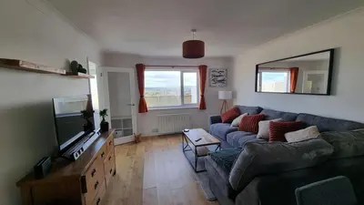 a living room with a couch and a tv at Heatherbell in Carbis Bay