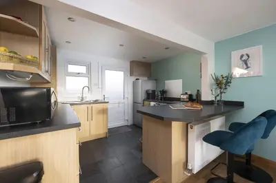 a kitchen with blue walls and a counter top at Ocean View, Mawgan Porth - Sea Views - Hot Tub - Free Parking & WiFi in Mawgan Porth