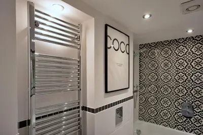 a bathroom with a walk in shower next to a wall at Finest Retreats - Pobbles Place in Fowey