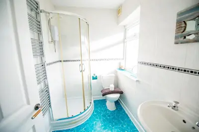a bathroom with a toilet and a tub and a sink at Seaside Home with Parking Near Tolcarne Beach in Newquay
