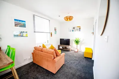 a living room with a couch and a tv at Seaside Home with Parking Near Tolcarne Beach in Newquay