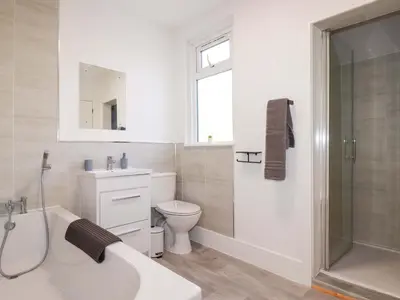 a bathroom with a toilet and a sink and a shower at Trevarthian in St Austell