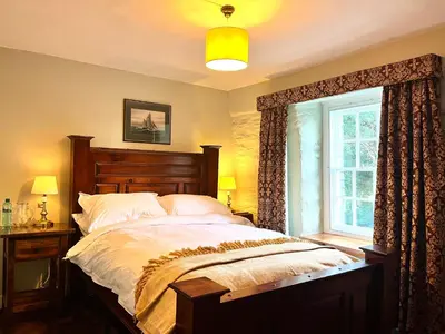 a bedroom with a large bed and a window at Trehaverne Cottage Truro in Truro