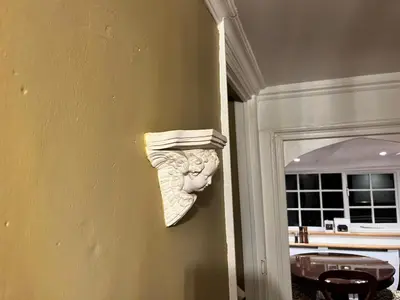 a plaster head on a wall next to a door at Trehaverne Cottage Truro in Truro