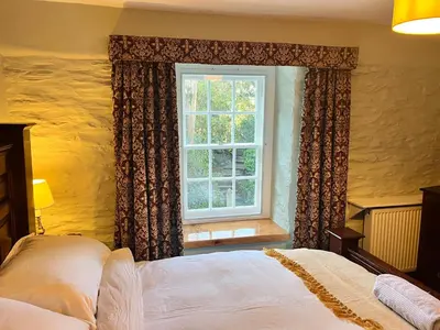 a bedroom with a bed and a window at Trehaverne Cottage Truro in Truro