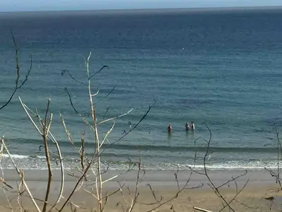 three people are in the water at the beach at Relaxing historic Roncon's Villa, The Paddock in Perranuthnoe