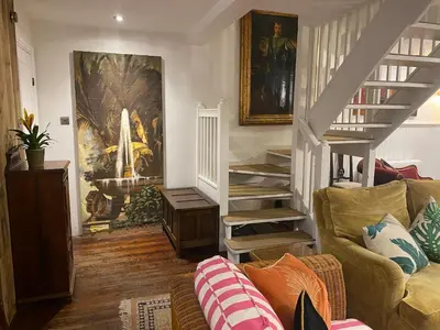 a living room with a staircase and a couch at Relaxing historic Roncon's Villa, The Paddock in Perranuthnoe