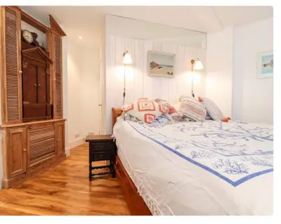 a bedroom with a large bed and a wooden floor at The Hexagon House in Penzance