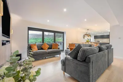 a living room with two couches and a kitchen at 4 Bed in St. Gennys oc-p34626 in Crackington Haven