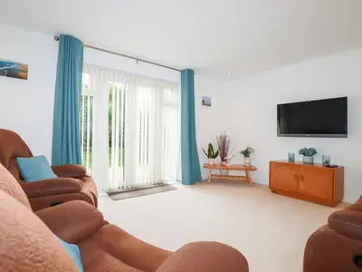a living room with two couches and a flat screen tv at Blissful Ocean Breeze in Perranporth