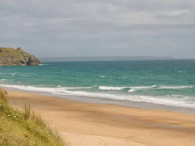 a sandy beach with the ocean in the background at Little Tregarrick in Helston