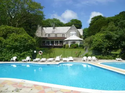 a swimming pool in front of a house at Villa 22 Lanteglos Hotel in Lanteglos