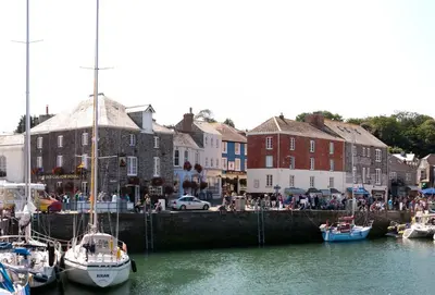 a group of boats docked in a harbor with buildings at Hardys in Padstow