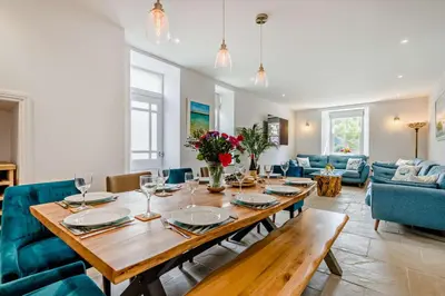 a dining room with a wooden table and blue chairs at 5 Bed in Porthleven oc-t24809 in Porthleven