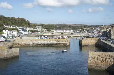 a boat in a river with a town in the background at 5 Bed in Porthleven oc-t24809 in Porthleven
