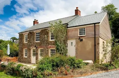 a brick house with a garage in front of it at Holly in Kea