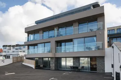 an apartment building with large glass windows at Groundfloor Apartment Opposite Beach with Parking in Newquay