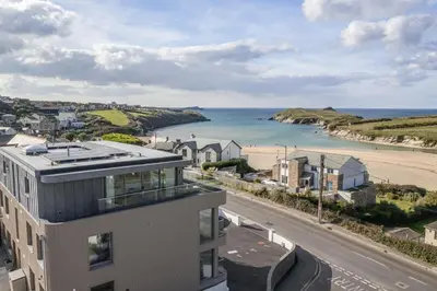 a building with a view of the ocean and a beach at Modern Groundfloor Apartment with Private Parking in Newquay