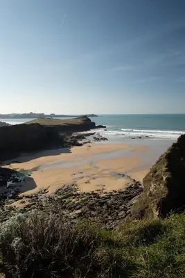 a sandy beach with the ocean in the background at Boho-Chic Apartment with Sea Views & Parking in Newquay
