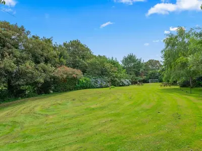 a grassy field with picnic tables in a park at Holiday Home Idyllisches Landhaus Rosemary by Interhome in Liskeard