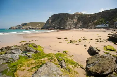 a beach with rocks and the ocean and a mountain at Cornish Cottage St Agnes free parking and garden in St. Agnes