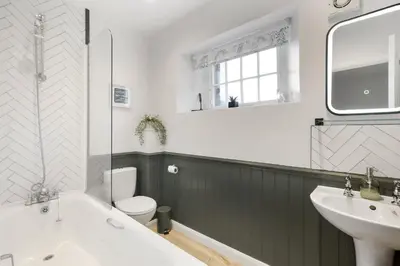 a bathroom with a tub and a sink and a toilet at Cosy Cottage nr Bodmin Moor Private Parking in Helland