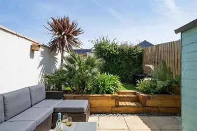 a garden with a couch and some plants at Stylish Home with Private Parking & Garden in Newquay