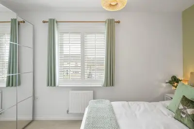 a bedroom with a bed and a window at Stylish Home with Private Parking & Garden in Newquay