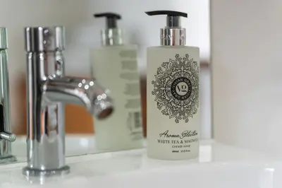 a bottle of soap sitting on a bathroom sink at Swift Barn Lambest Farm Menheniot Cornwall in Menheniot
