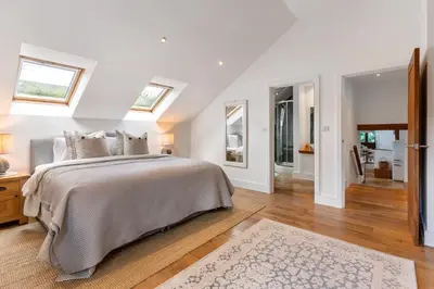 a white bedroom with a large bed and skylights at Swift Barn Lambest Farm Menheniot Cornwall in Menheniot