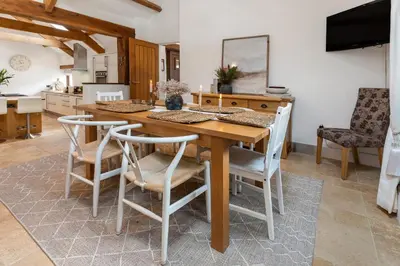 a dining room with a wooden table and chairs at Swift Barn Lambest Farm Menheniot Cornwall in Menheniot