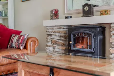 a living room with a fireplace and a couch at 2 Bedroom Cottage Close to Perranporth Beach in Roche