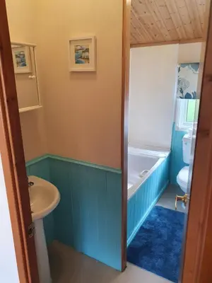a bathroom with a sink and a toilet and a tub at The Retreat in Polperro