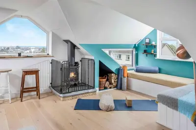 a room with a bed and a fire place in it at Parkland Place - Spacious Newquay family holiday home, parking, log burner, dog friendly in Saint Columb Minor