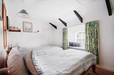 a bedroom with a bed and a window at Crotchet Cottage near sandy beach at Porthbeor in Saint Anthony