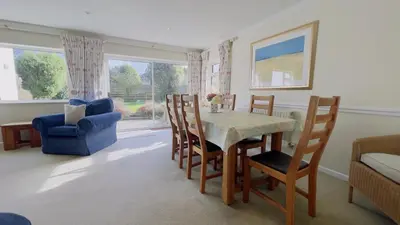 a living room with a dining room table and chairs at Seamist Rock - on the north coast of Cornwall in Roche