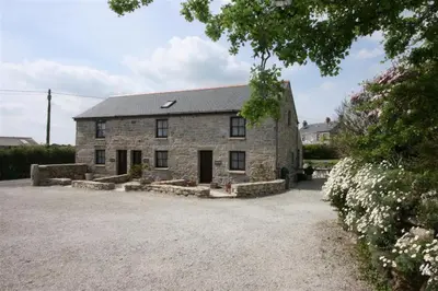 an old stone house with a gravel driveway at Thumbelina far reaching views of the countryside in Budock Water