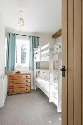 a bedroom with two bunk beds and a dresser at Trotters barn conversion on edge of Mount Hawke in Mount Hawke