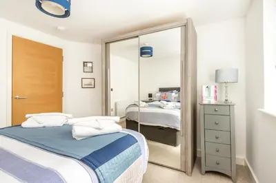 a small bedroom with a mirror and a bed at Zephyr in Fowey