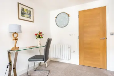 a desk with a chair and a table and a door at Zephyr in Fowey