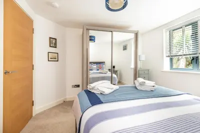 a bedroom with a bed and a mirror at Zephyr in Fowey
